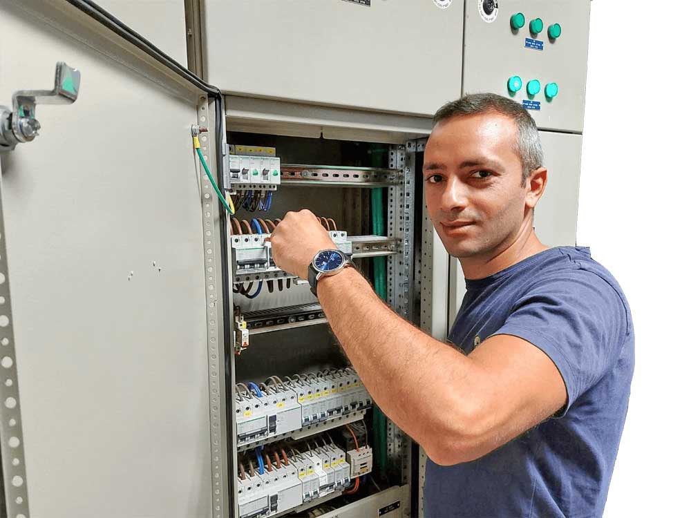 דוד מלכי חשמלאי מוסמך מבצע עבודת תחזוקה בלוח חשמל תעשייתי